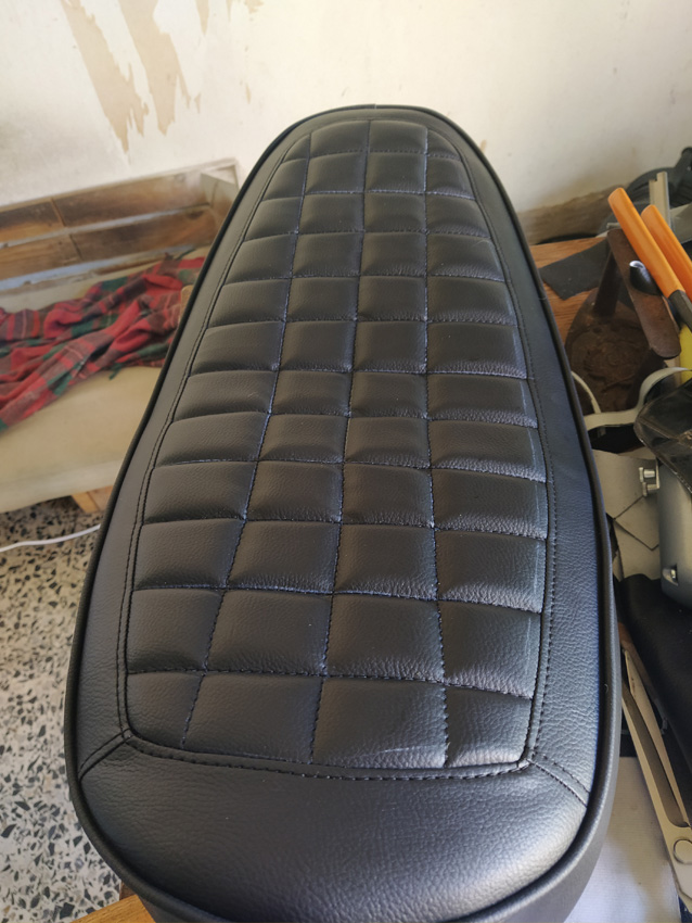 Selle de moto noire matelassée avec motif en damier et surpiqûres bleues